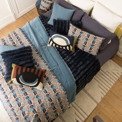 lit habillé avec linge de lit dans les tons bleus