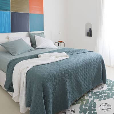 lit double avec linge de lit et couvre-lit tons bleu